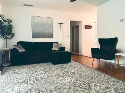 sala de estar con sofá negro y 2 sillas en Modern SD Oasis with Pool & HotTub, en San Diego