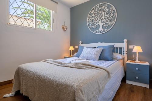 a bedroom with a bed and a tree picture on the wall at Complejo Colibri 8 in Cambrils