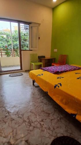a bedroom with a large bed and two chairs at Shree krishna homestay in Hampi