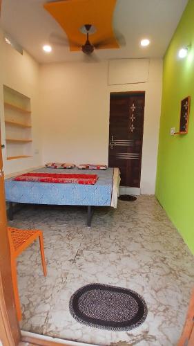 a bedroom with a bed and a green wall at Shree krishna homestay in Hampi