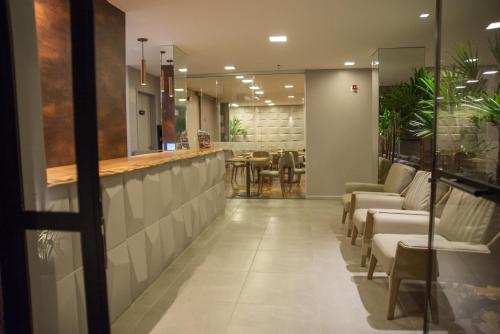 a lobby with chairs and a bar with a table at Amenit Hotel in Maceió