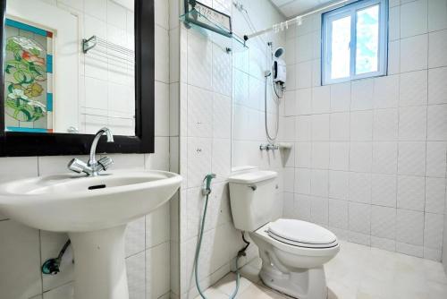a white bathroom with a sink and a toilet at Boracay Breeze Resort in Boracay