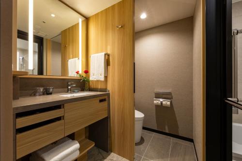 a bathroom with a sink and a toilet and a mirror at Hotel Nikko Fukuoka in Fukuoka