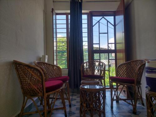a group of chairs in a room with a window at two goats fair travel in Rājpur