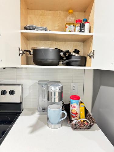 a kitchen counter with a coffee maker and a coffee pot at Elegant Modern Suite with Comfort & Privacy in Regina
