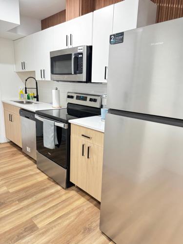 a kitchen with a stainless steel refrigerator and a microwave at Elegant Modern Suite with Comfort & Privacy in Regina