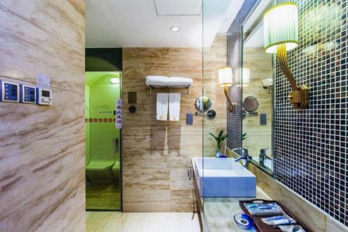 a bathroom with a sink and a shower at Centenio International Hotel in Xiaotang