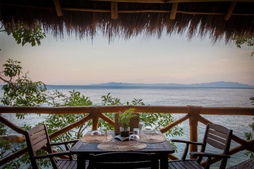 a table with chairs and a view of the ocean at Xinalani Retreat Mexico in Qumiste