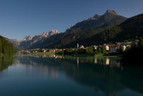 a large body of water with a town and mountains at Albergo Meublè Victoria in Auronzo di Cadore