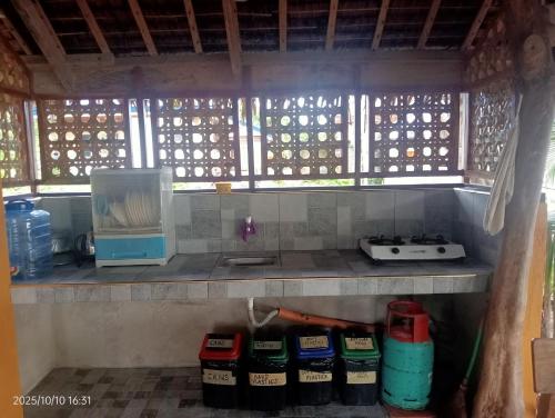 a kitchen with a stove and a microwave on a shelf at Goldsky Seaview Resort in San Juan