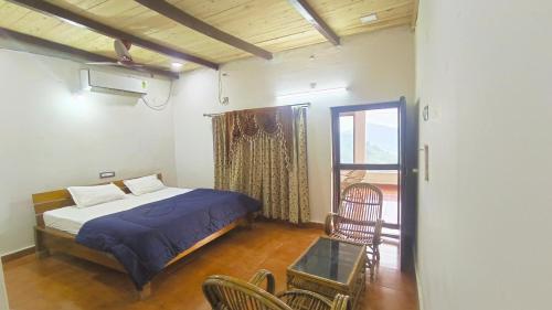 a bedroom with a bed and a table and chairs at Kings Court Village Resort in Araku