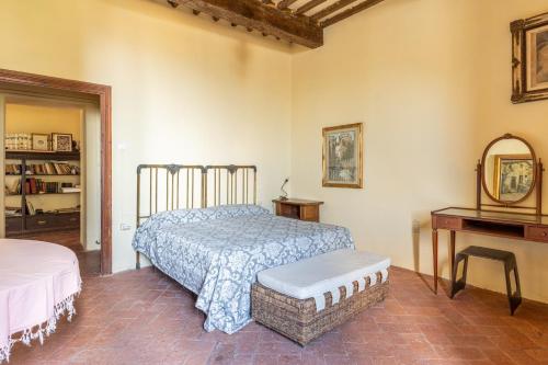 a bedroom with a bed and a table and a mirror at Casa do sol villa barbacci in Montevettolini