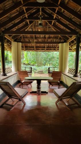 a group of chairs and a table in a room at KOKDEERI NATURE HOME in Malappuram