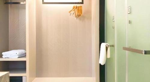 a bathroom with a shower with a glass door at Echarm Hotel Enshi Cultural Center Xintiandi in Enshi