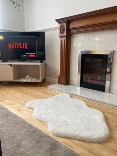 a living room with a fireplace and a white rug at Modern apartment in Glasgow West End, free parking in Scotstoun West Station