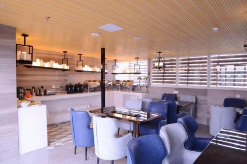福州市にあるEcharm Hotel Fuzhou Sanfang Qixiang East Street Metro Stationの青い椅子とダイニングルームのあるレストラン