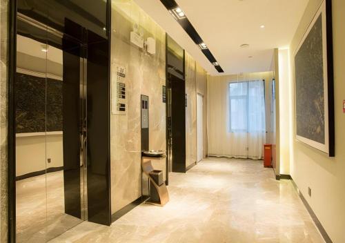 a hallway with a glass elevator in a building at Echarm Hotel Wuhan Hankou Station Changgang Road Metro Station in Wuhan