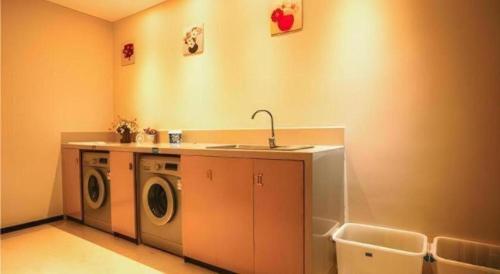 - une buanderie avec un lave-linge et un évier dans l'établissement City Comfort Inn Xianning Tongcheng Zhuangyuan Square, à Tongcheng
