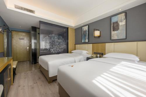 Postel nebo postele na pokoji v ubytování Jinyi Hotel Bayannur Linhe Victoria Mall Branch