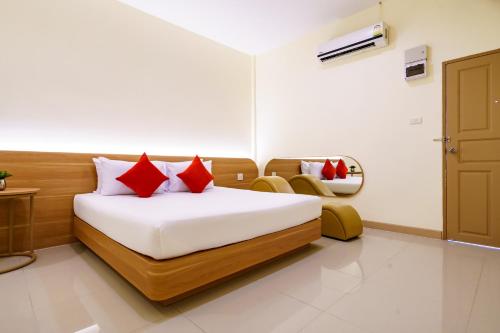 a bedroom with a bed with red pillows on it at OK Resort Banchang in Ban Chang