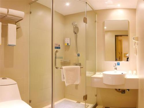 une salle de bain avec douche et lavabo dans l'établissement City Comfort Inn Guiyang Jiefang Road Hongtongcheng, à Guiyang