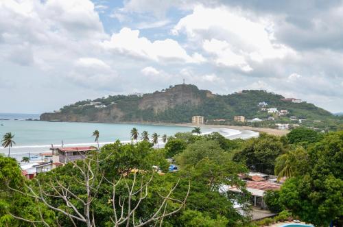 a view of a beach with a hill in the background at Nuestra Casa in San Juan del Sur