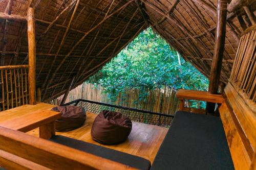 a room with a bench in a straw hut at Bamboo Jungle Villa's in El Nido