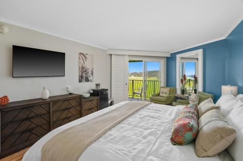 Un dormitorio con una cama grande y un televisor de pantalla plana. en Kauai Dreams Escape I, en Lihue