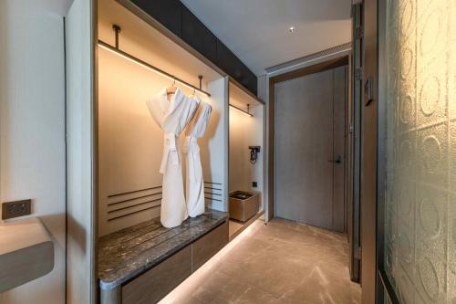 a dressing room with a robe hanging on a wall at Nous Land Beijing in Beijing