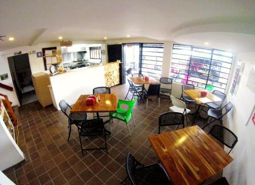 a restaurant with tables and chairs and a kitchen at Hostal de la 57 in Manizales