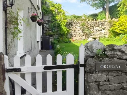 a white picket fence in front of a house at Oronsay Cottage in Great Urswick