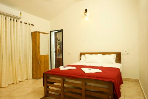 a bedroom with a bed with two towels on it at The Beach Hive in Kappil