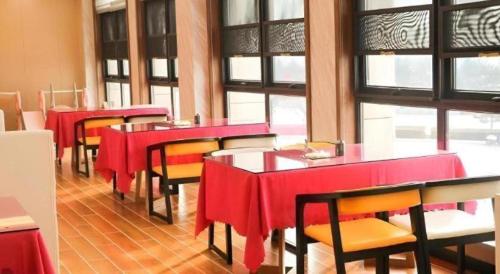 un restaurant avec des tables rouges, des chaises et des fenêtres dans l'établissement GreenTree Inn Shanxi Linfen Huozhou High-Speed Railway Station, à Huozhou