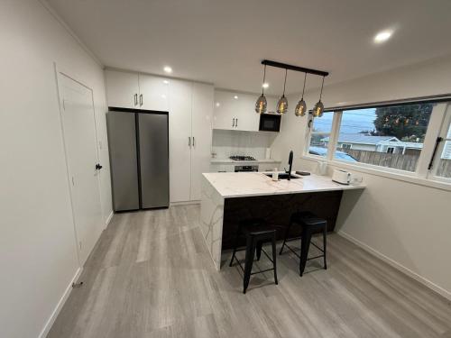 a kitchen with a island with two stools in it at Gee's House in Upper Hutt