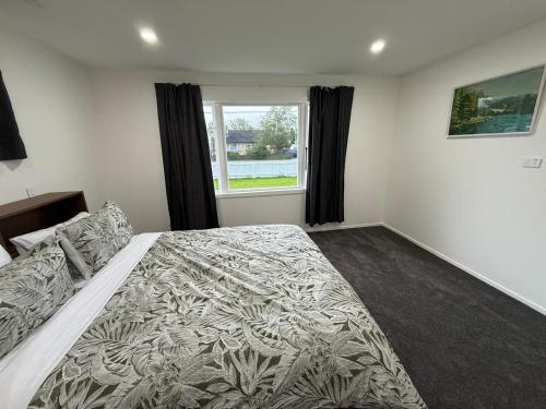 a bedroom with a large bed and a window at Gee's House in Upper Hutt
