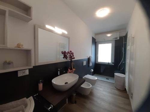 a bathroom with a sink and two toilets in it at Appartamento Marilu Lake View in Brenzone sul Garda
