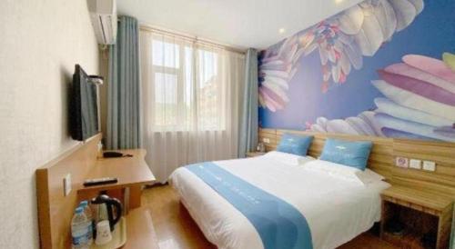 a bedroom with a bed and a desk and a tv at PAI Hotel Shijiazhuang Luquan Zoo in Luquan