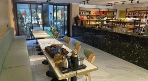 un restaurant avec une table et des chaises ainsi qu'un bar dans l'établissement Jun Hotel Hunan Yongzhou Ningyaun Shundi Plaza, à Ningyuan