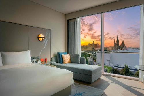 a bedroom with a bed and a chair and a large window at Nous Land Beijing in Beijing