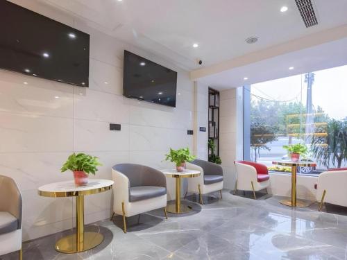 ShangqiuにあるGreenTree Inn Express Shangqiu Beihai Road South Railway Stationの椅子、テーブル、テレビが備わる待合室
