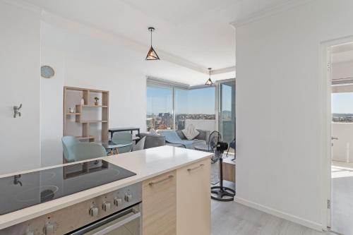 Una cocina abierta con vistas a la sala de estar. en Stylish 2-Bedroom Sea-View Apartment Horizon Bay Blouberg Beachfront, en Cape Town