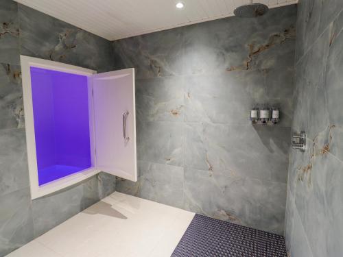IngramにあるHoneymugの壁に紫色の窓があるバスルーム