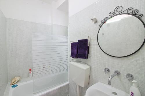 ein Badezimmer mit einem Spiegel, einem Waschbecken und einem WC in der Unterkunft Apartment São Lourenço in Lissabon