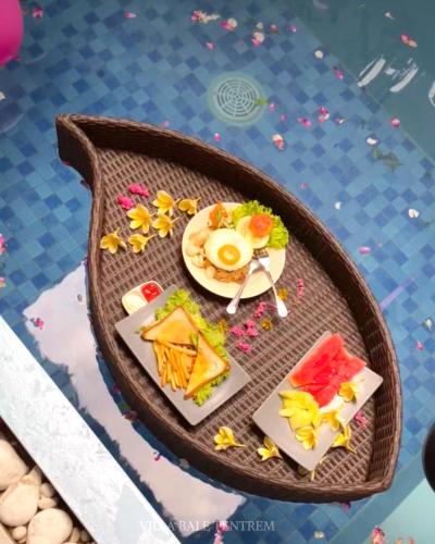 ein Tisch mit einem Teller Essen darauf in der Unterkunft Villa Bale Tentrem Pamungkas in Ngemplak