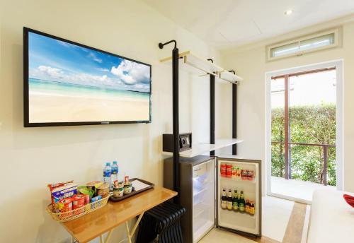 een televisie die aan de muur boven een koelkast hangt bij Siam Royal View Resort Apartments in Ko Chang