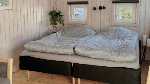 - un lit non aménagé dans une chambre avec 2 fenêtres dans l'établissement Vakantiehuis Vlakbij Zee En Gezellig Sæby, à Sæby