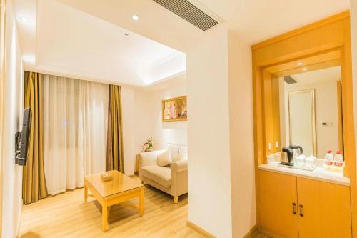 a living room with a couch and a table at Vienna Hotel Guangdong Foshan Wenhua North Road in Nanhai