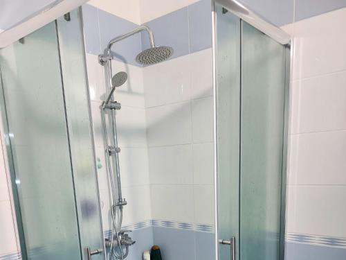 a shower with a glass door in a bathroom at Albert's house for rent in Vlorë