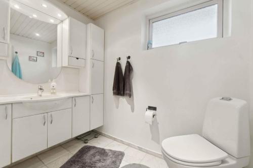 a bathroom with a toilet and a sink and a window at Lovely Holiday Home By The Limfjord in Storvorde