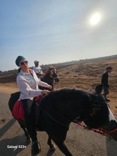 a woman riding a horse down a road at MUMA Lodge in Marrakech